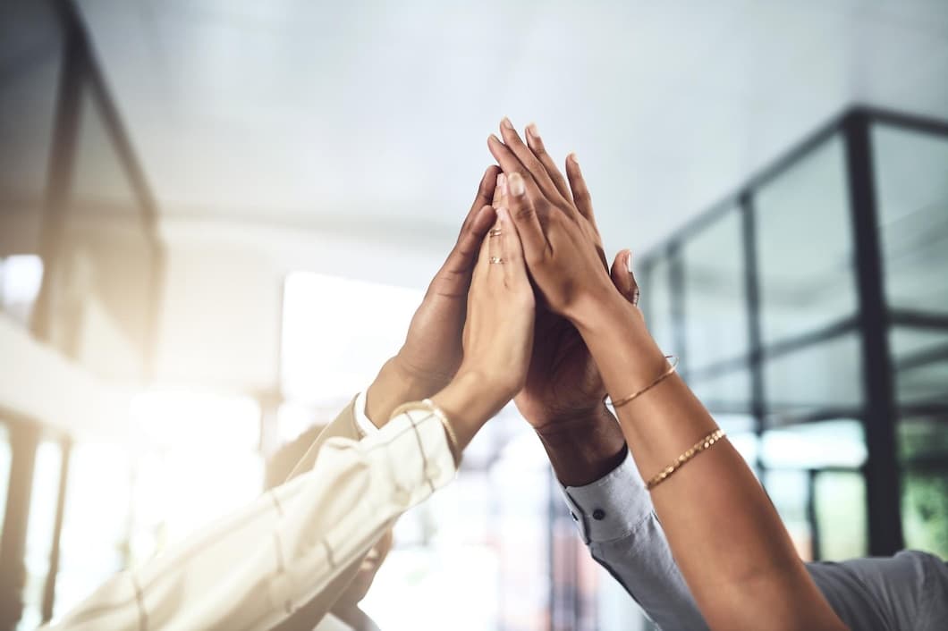 Colleagues sharing a high five in a bright office