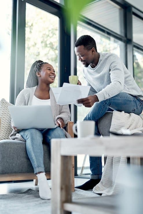 A couple reviewing insurance paperwork and policy documents together at home