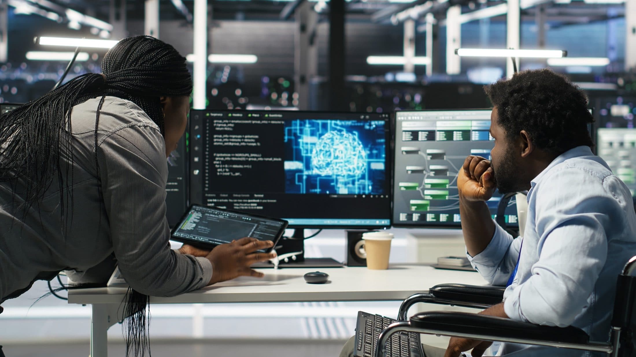 Two colleagues reviewing AI-assisted monitoring tools in a data centre